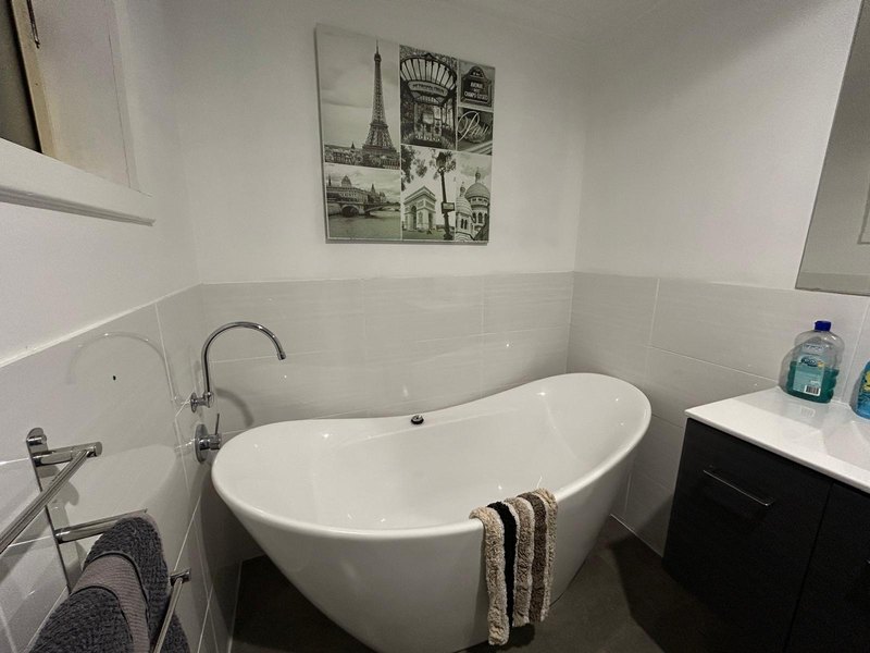 Main bathroom with freestanding bath and dark vanity