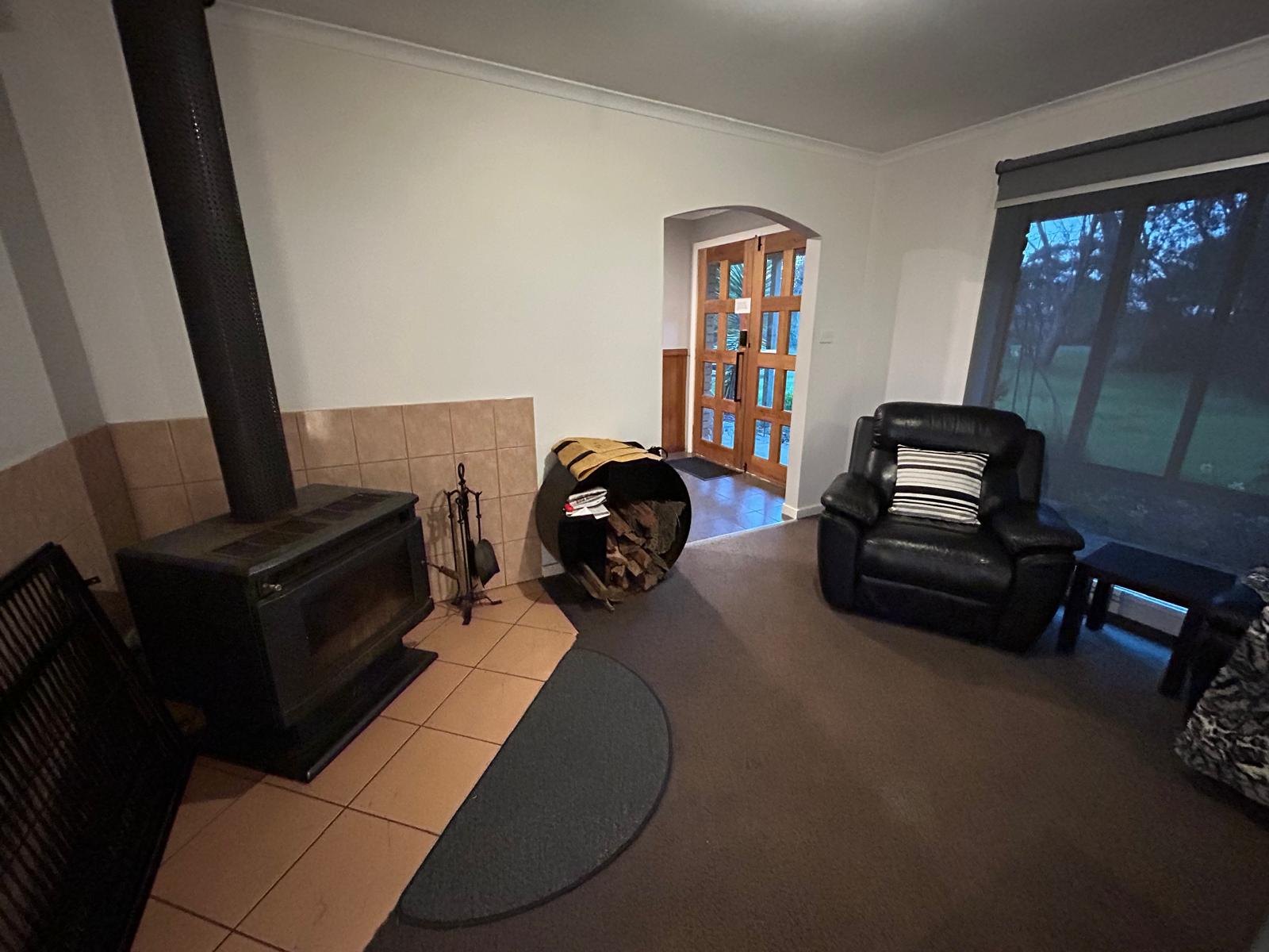 Living room with wood fire, leather recliners and big windows to the garden